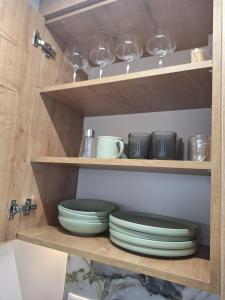 una mensola in legno con piatti e bicchieri di Mateo rezidence a Bistriţa