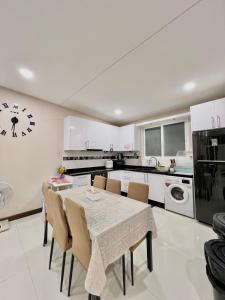 una cocina con mesa y sillas y un reloj en la pared en Beach home pool villa bangsaray, en Bang Sare