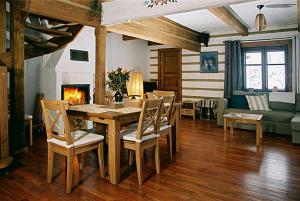 a living room with a table and chairs and a fireplace at Hnatowa Chata in Wetlina