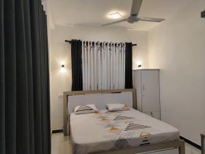 een slaapkamer met een bed in een kamer met gordijnen bij Green Haven Villa in Hikkaduwa