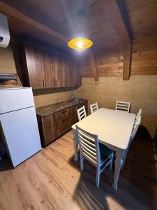 una cucina con un tavolo e un frigorifero bianco di Villa Nuovo Monte a Novoberdo