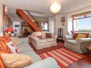a living room with two couches and a staircase at Rogeston Mount - Cottage in Nolton