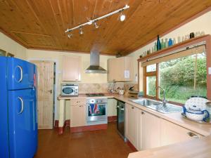 a kitchen with a blue refrigerator and a sink at Rogeston Mount - Cottage in Nolton