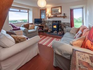a living room with two couches and a fireplace at Rogeston Mount - Cottage in Nolton +28 photos