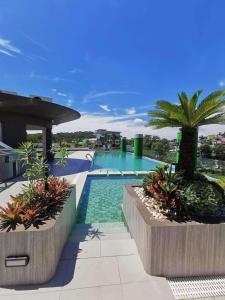 ein Swimmingpool mit Palmen und ein Resort in der Unterkunft Skyline Pines City Hub - Baguio in Baguio City
