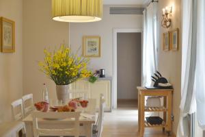 een eetkamer met een tafel en stoelen en een vaas met bloemen bij Fonteliving RestArt in San Casciano dei Bagni +187 foto's