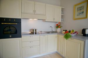 een keuken met witte kasten en een zwart apparaat bij Fonteliving RestArt in San Casciano dei Bagni