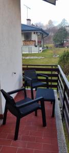 2 sedie e un tavolo sul balcone di Residence ai fiori - Simone Apartment ad Arta Terme