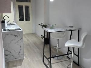 een keuken met een marmeren aanrecht en twee krukken bij Lena Apartmani 5 in Odžaci