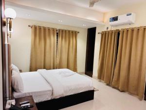 ein Hotelzimmer mit Bett und Vorhängen in der Unterkunft Grand Khalifa Hotel Hamama in Sylhet + 1 Foto