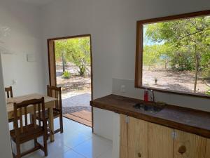 a kitchen with a sink and a table and a window at Casa Moreré in Ilha de Boipeba