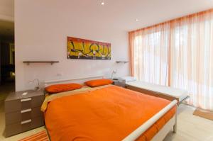 een slaapkamer met een bed met een oranje dekbed bij 149 Dimora di autore in Borca di Cadore
