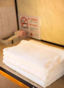 a stack of white towels on a counter next to a microwave at AKKARA RESORT&VILLA in Chiang Rai