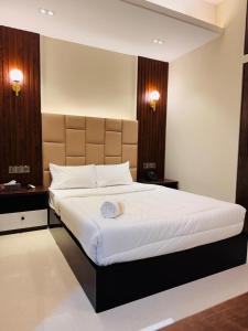 ein Schlafzimmer mit einem großen Bett mit weißer Bettwäsche in der Unterkunft Grand Khalifa Hotel Hamama in Sylhet
