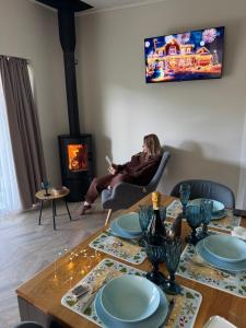a woman sitting in a chair in a living room with a table at Grey apartments in Slavske