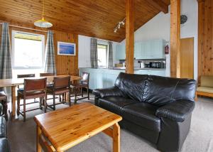 een woonkamer met een leren bank en een tafel bij Lochearnhead Loch Side in Lochearnhead +21 foto's