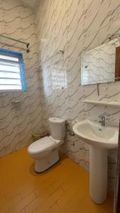 une salle de bains avec toilettes et lavabo dans l'établissement Les Residences Belani - Cadjehoun, Cotonou, à Kika