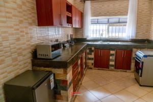 a kitchen with a counter top with a microwave at ExpressFitnessUG in Jinja
