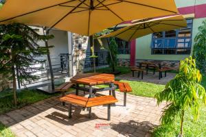 a picnic table and chairs under an umbrella at ExpressFitnessUG in Jinja