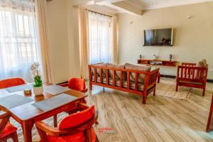 a living room with a table and chairs and a couch at ExpressFitnessUG in Jinja