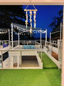 patio con lámpara de araña, mesa y sillas en De' ozone ongsa pool villa หน้าหาดบางเสร่, en Bang Sare