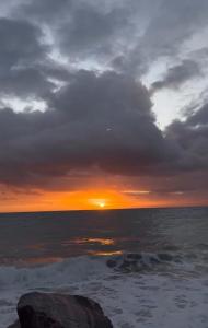 Un tramonto sull'oceano sotto un cielo nuvoloso di Brisa do Oceano - Pousada & Hostel a Caucaia