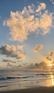 una spiaggia con cielo nuvoloso e l'oceano di Brisa do Oceano - Pousada & Hostel a Caucaia