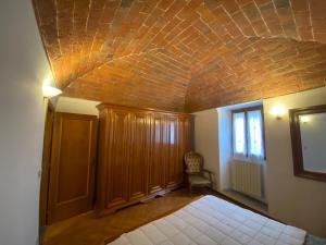 een kamer met een bed en een bakstenen plafond bij Lo Sdrucciolo in Laterina