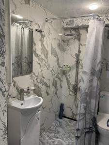 Un baño blanco con lavabo y ducha. en METROMIR Hotel, en Ereván