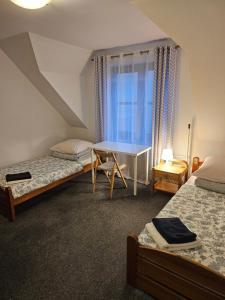 una camera da letto con due letti, una scrivania e una finestra di Pokoje w ,,Stajni ,, a Niemce