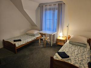 una camera da letto con due letti, una scrivania e una finestra di Pokoje w ,,Stajni ,, a Niemce Altre 16 foto