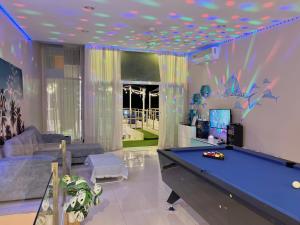a living room with a pool table in it at De' ozone ongsa pool villa หน้าหาดบางเสร่ in Bang Sare