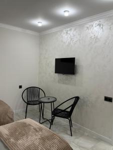 Una habitación con dos sillas y un televisor en una pared. en METROMIR Hotel, en Ereván