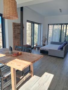 a living room with a wooden table and a bed at Sea Breeze Ecological Villa in Agia Galini