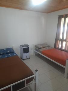 a room with two beds and a heater in it at Cabañas San Benito in Los Antiguos