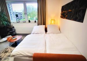 En eller flere senge i et værelse på Getaway Apartment mit Balkon - großem Doppelbett & Schlafsofa für insg 4 Pers - ruhig gelegen, ideal zum Wohlfühlen&Ankommen - Kinderbett&Hochstuhl - Messe Düsseldorf&Essen - S-Bahn