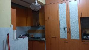 a kitchen with wooden cabinets and a door in a kitchen at el-yusra homestay in Bayan Lepas