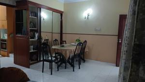 a dining room table and chairs in a room at el-yusra homestay in Bayan Lepas
