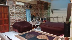 a living room with a table and a brick wall at el-yusra homestay in Bayan Lepas
