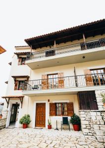 ein Gebäude mit Balkon und zwei Stühlen in der Unterkunft Studios EYTYXIA-3 in Kalavryta