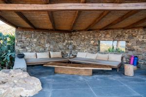 een woonkamer met banken en een stenen muur bij Luxury Villa Delphinus - AllParos Villas in Paraspóri