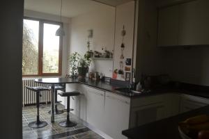 eine Küche mit einem Tisch und 2 Barhockern in der Unterkunft Chambre spacieuse proche du centre ville in Villefranche-de-Rouergue