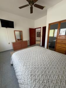 a bedroom with a large bed and a ceiling fan at Casa Vemisa Puerto Escondido in Puerto Escondido