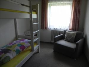 ein Schlafzimmer mit einem Etagenbett und einem Stuhl in der Unterkunft Ferienwohnung Schautzgy in Reutte