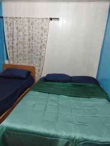 een slaapkamer met 2 bedden met blauwe lakens bij Quarto N II Cama casal e uma de solteiro in Gramado