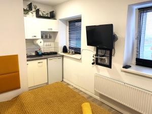 a small kitchen with a tv on the wall at Lemuria Studio Łokietka in Legnica