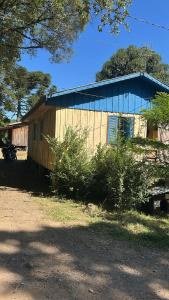een klein huisje met een blauw dak bij Quarto N II Cama casal e uma de solteiro in Gramado