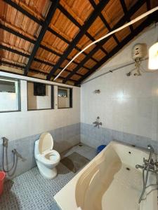 une salle de bain avec toilettes et baignoire dans l'établissement Coastal Nest Home - Malpe Beach, à Malpe