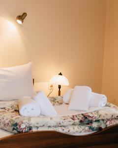 ein Bett mit weißen Kissen und einer Lampe darauf in der Unterkunft Studios EYTYXIA-3 in Kalavryta