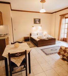 ein Schlafzimmer mit einem Bett und einem Tisch darin in der Unterkunft Studios EYTYXIA-3 in Kalavryta